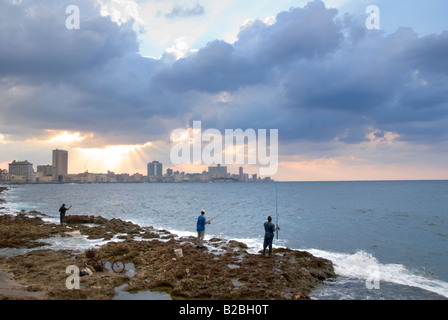 Persone di pesca da El Malecon con vista su tutta la baia verso Vedado Avana Cuba Foto Stock