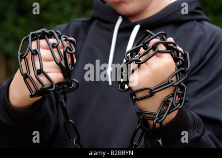 Catena di metallo avvolto intorno a pugno di ragazzi Foto Stock