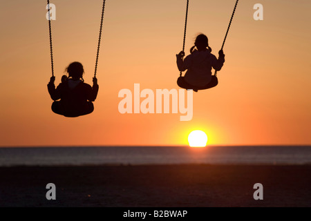 Due ragazze, 8- e 12-anno-vecchio, guardando un tramonto sul Mare del Nord, San Peter-Ording, Frisia settentrionale, Schleswig-Holstein, Nord tedesco Foto Stock