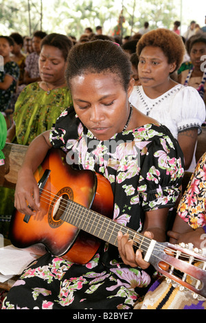 Donna di suonare una chitarra, durante un servizio di chiesa, Madang, Papua Nuova Guinea, Melanesia Foto Stock