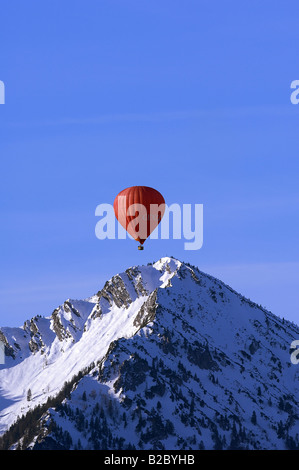 Red mongolfiera galleggianti al di sopra del picco di Mt. Ochsenkamp, Montgolfiade, Tegernsee, Bad Wiessee, Baviera, Germania, Europa Foto Stock