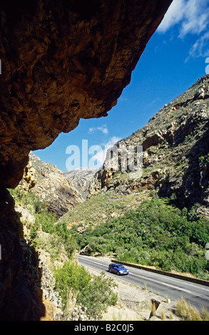 Auto guidando lungo una strada asfaltata attraverso un paesaggio di montagna, Groot Swartberge, Provincia del Capo, in Sud Africa e Africa Foto Stock