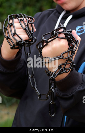 Catena di metallo avvolto intorno a pugno di ragazzi Foto Stock