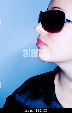 Giovane donna con occhiali da sole, side-face Foto Stock