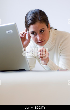 Giovane donna sdraiata su un lettino e lavorare con un notebook Foto Stock