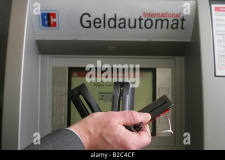 Dipendente della Banca dimostrando dispositivi tecnici utilizzati dai criminali per spiare i numeri e codici pin di carte bancarie in una macchina ATM Foto Stock