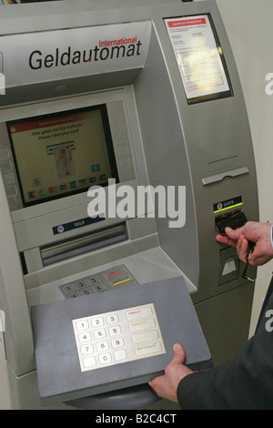 Dipendente della Banca dimostrando dispositivi tecnici utilizzati dai criminali per spiare i numeri e codici pin di carte bancarie in una macchina ATM Foto Stock