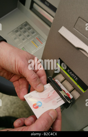 Dipendente della Banca dimostrando dispositivi tecnici utilizzati dai criminali per spiare i numeri e codici pin di carte bancarie in una macchina ATM Foto Stock