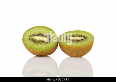 Kiwi (Actinidia deliciosa), tagliate a metà Foto Stock