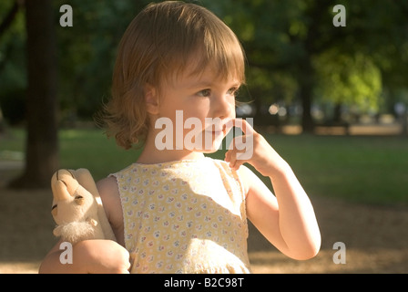 Bambina nel parco con il giocattolo di peluche Foto Stock