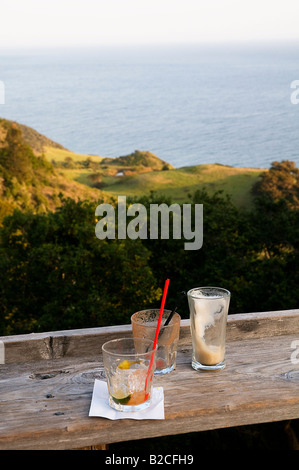 Tre cocktail e/o bicchieri da birra seduti su un tavolo bar presso una caffetteria il Big Sur si affaccia sull'Oceano Pacifico Foto Stock