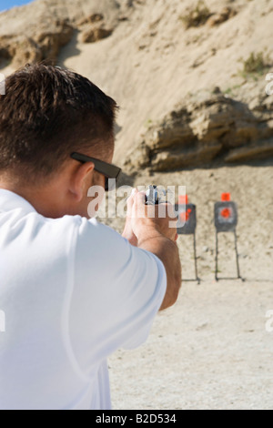 Man mano di puntamento pistola a poligono di tiro Foto Stock