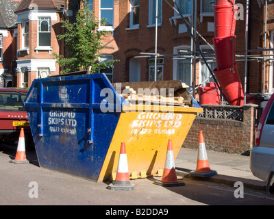 Un costruttore di saltare al di fuori di una casa che è in fase di ristrutturazione. Foto Stock