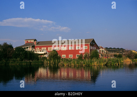 Una vista alcuni dei vecchi edifici di colore rosso nel vecchio quartiere di Mulino lungo il fiume Deschutes nel picco di autunno nella curvatura Oregon Foto Stock