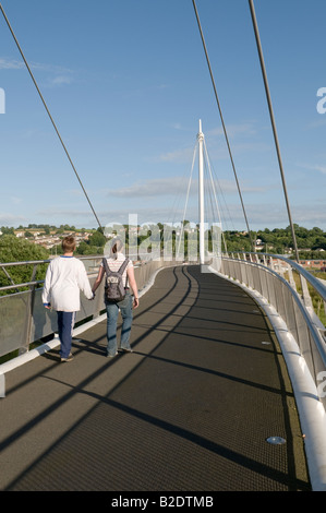 Due persone attraversando il Pont re Morgan sospensione passerella sul fiume Tywi a Carmarthen Wales UK Foto Stock