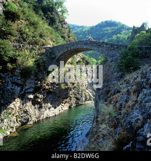 Donna seduta su Pont du Diable, ponte del Diavolo a strapiombo sul fiume Ardèche, Gorges de l'Ardèche,Thueyts, Auvergne Francia Europa Foto Stock