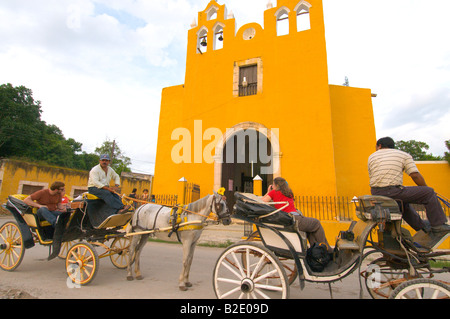 Woman in Red camicetta con un punto digitale fotografare una chiesa da un carro trainato da cavalli Izamal Yucatan Messico Foto Stock