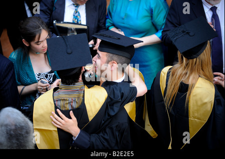 Università del Sussex estate graduazioni a Brighton Dome - due laureati bere un toast uno all'altro. Foto Stock