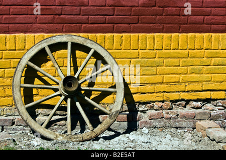 Vecchia ruota di legno contro una parete Foto Stock