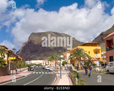 Giovane camminare tenendo le mani con cane vicino road, Valle Grana Rey, La Gomera, isole Canarie, Spagna Foto Stock