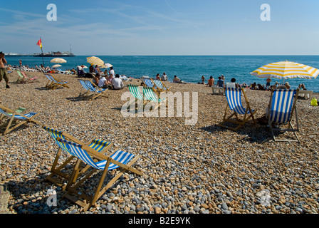 Sedie a sdraio e turisti sulla Spiaggia Brighton East Sussex England Foto Stock