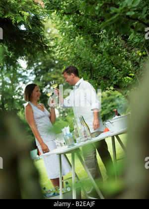 Accoppiare la tostatura con wineglasses in giardino Foto Stock