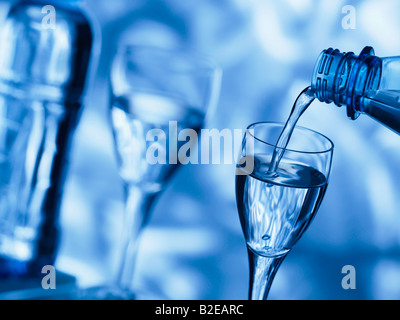 Close-up di acqua versata nel bicchiere a stelo Foto Stock