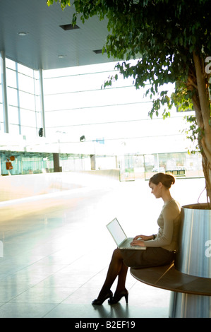 Profilo laterale di una imprenditrice al lavoro su un notebook Foto Stock
