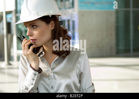 Close-up di una giovane donna che parla su un walkie-talkie Foto Stock