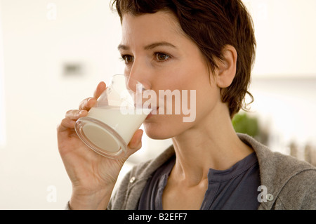 Close-up di una metà donna adulta bere un bicchiere di latte Foto Stock
