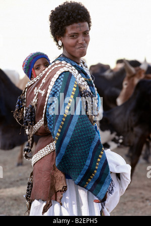 Un Tigray donna porta il suo bambino in una splendidamente decorate portante in pelle sulla schiena. Foto Stock