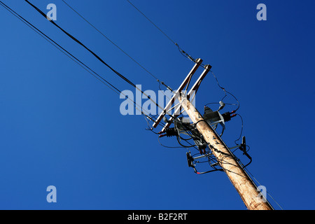 Le linee elettriche di alimentazione supportato su un palo di legno Foto Stock