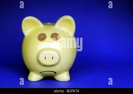 GLUM CERCANDO BRITISH PIGGYBANK con bocca DOWNTURNED, re di recessione prestiti risparmio redditi ipoteche COSTO DELLA VITA ETC UK. Foto Stock