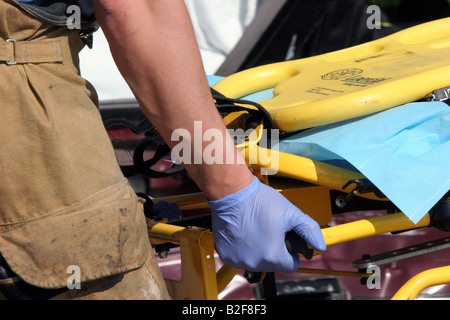 Un lavoratore di EMS preparare il stetcher per una vittima di essere caricato dopo un incidente per essere trasportato in ospedale Foto Stock