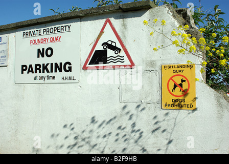 Cartelli di avvertimento sul vecchio muro Fonderia Quay Hayle Cornovaglia Foto Stock