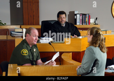 Sotto l'occhio vigile di un Africano giudice americano un vice sherrif testimonia in un Southern California courtroom Foto Stock