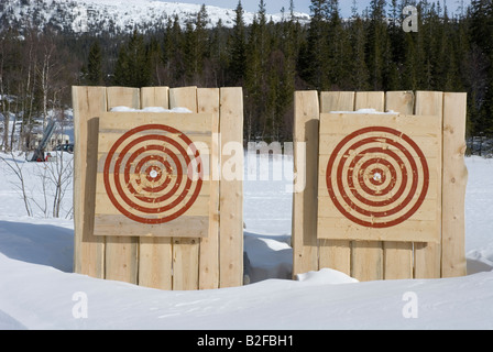 Coppia di bersagli di legno nella neve con pochi segni fatti da frecce e assi Foto Stock