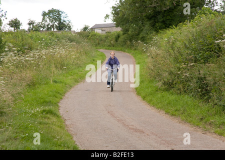 Donna in bicicletta nel Northumberland Inghilterra Foto Stock