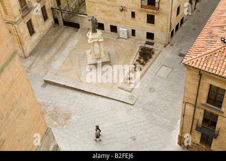 Spagna Salamanca vista aerea di due persone a piedi attraverso la città plaza in pietra con statua vista dalla piattaforma della Cattedrale Foto Stock