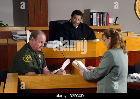 Sotto l'occhio vigile di un Africano giudice americano un vice sherrif testimonia in un Southern California courtroom Foto Stock