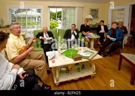 Un anziano musicista suona folk irlandese canzoni su un ukelele per un pubblico molto entusiasta di Stoneham Massachusetts Foto Stock