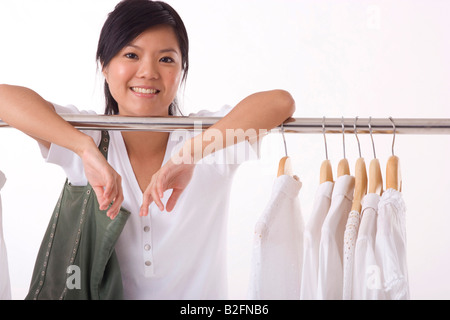 Ritratto di una giovane donna appoggiata su un portabiti Foto Stock
