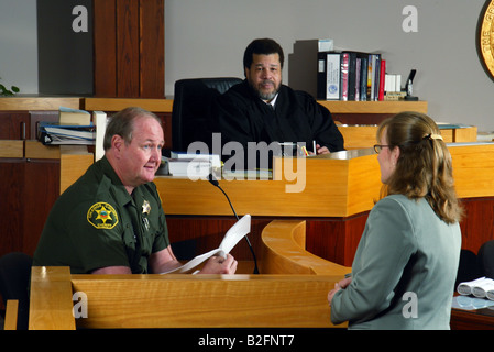 Sotto l'occhio vigile di un Africano giudice americano un vice sherrif testimonia in un Southern California courtroom Foto Stock