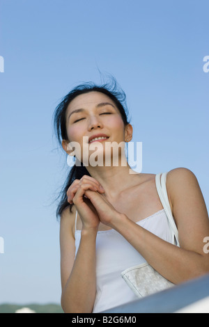 Close-up di una giovane donna in posizione di preghiera Foto Stock