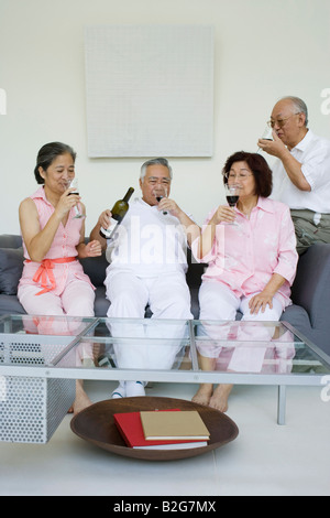Due coppie senior seduti insieme e bere il vino Foto Stock
