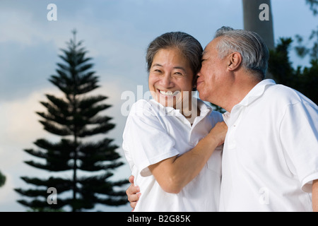 Senior uomo baciare una donna senior Foto Stock