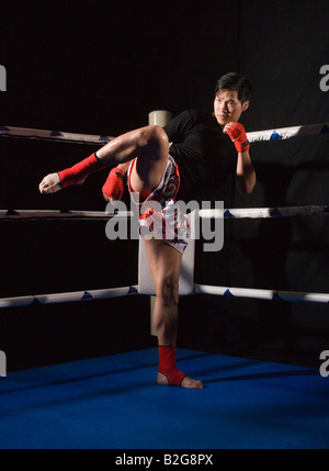 Metà uomo adulto praticano kickboxing in un anello di inscatolamento Foto Stock