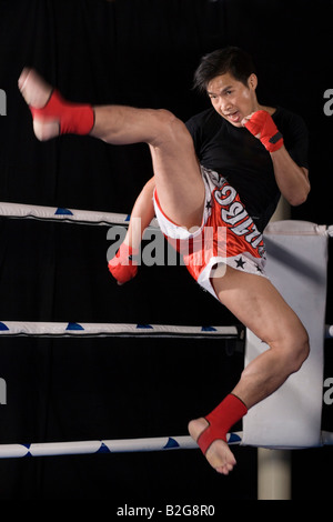 Metà uomo adulto praticano kickboxing in un anello di inscatolamento Foto Stock