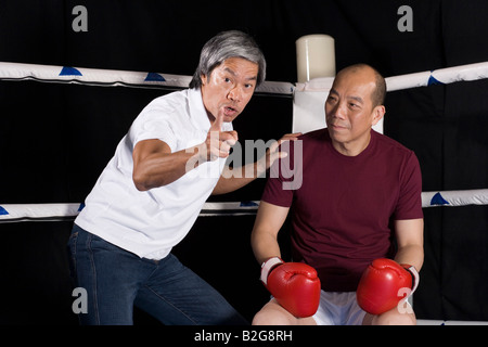 Uomo maturo appoggiato con il suo allenatore istruire lui Foto Stock