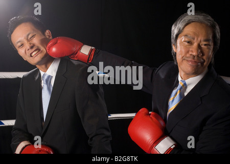 Due imprenditori combattendo in un anello di inscatolamento Foto Stock